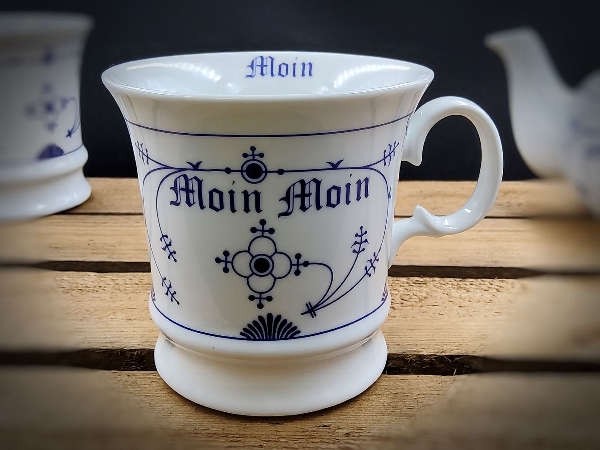 Weiße Tasse aus Porzellan mit indisch blauen Ornamenten und dekorativer Schrift
